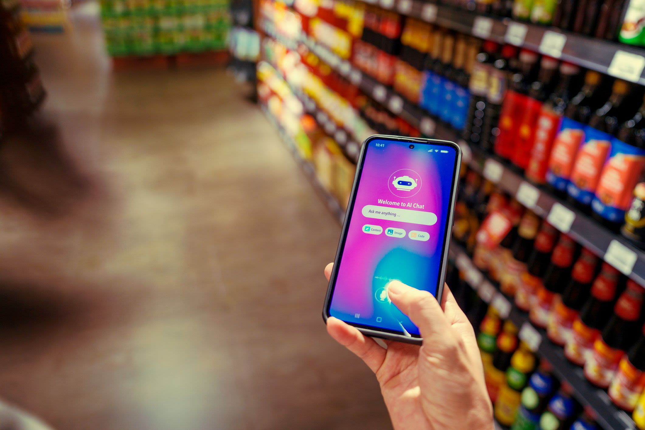 A person uses an AI chatbot app on a smartphone inside a grocery store, with shelves of products in the background.