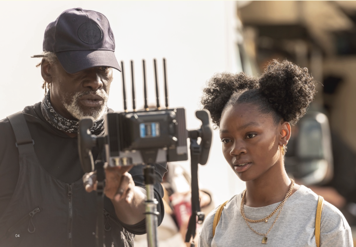 Man and woman looking at a small production monitor during filming of ad