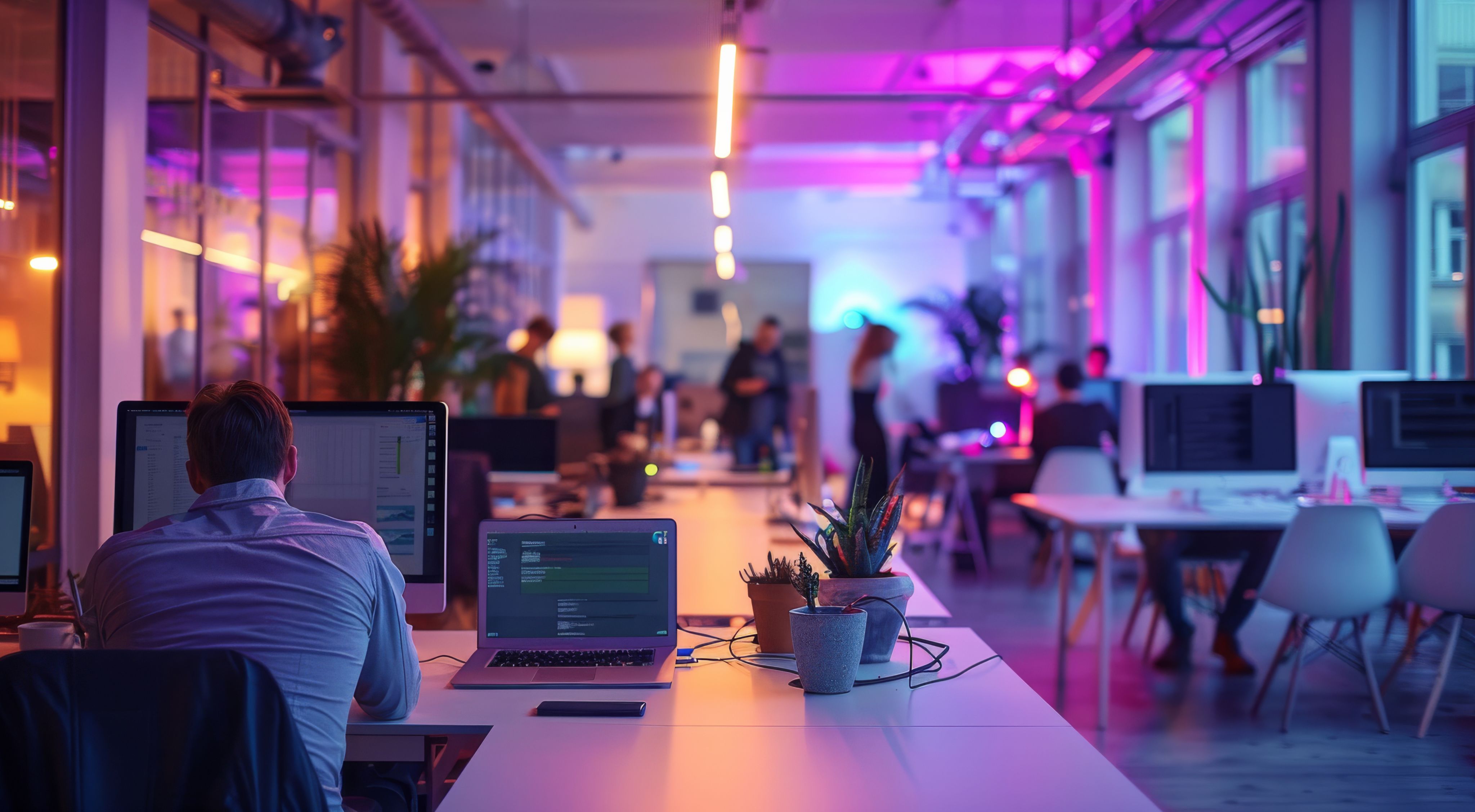 Office with people sitting at desks and standing, talking to each other