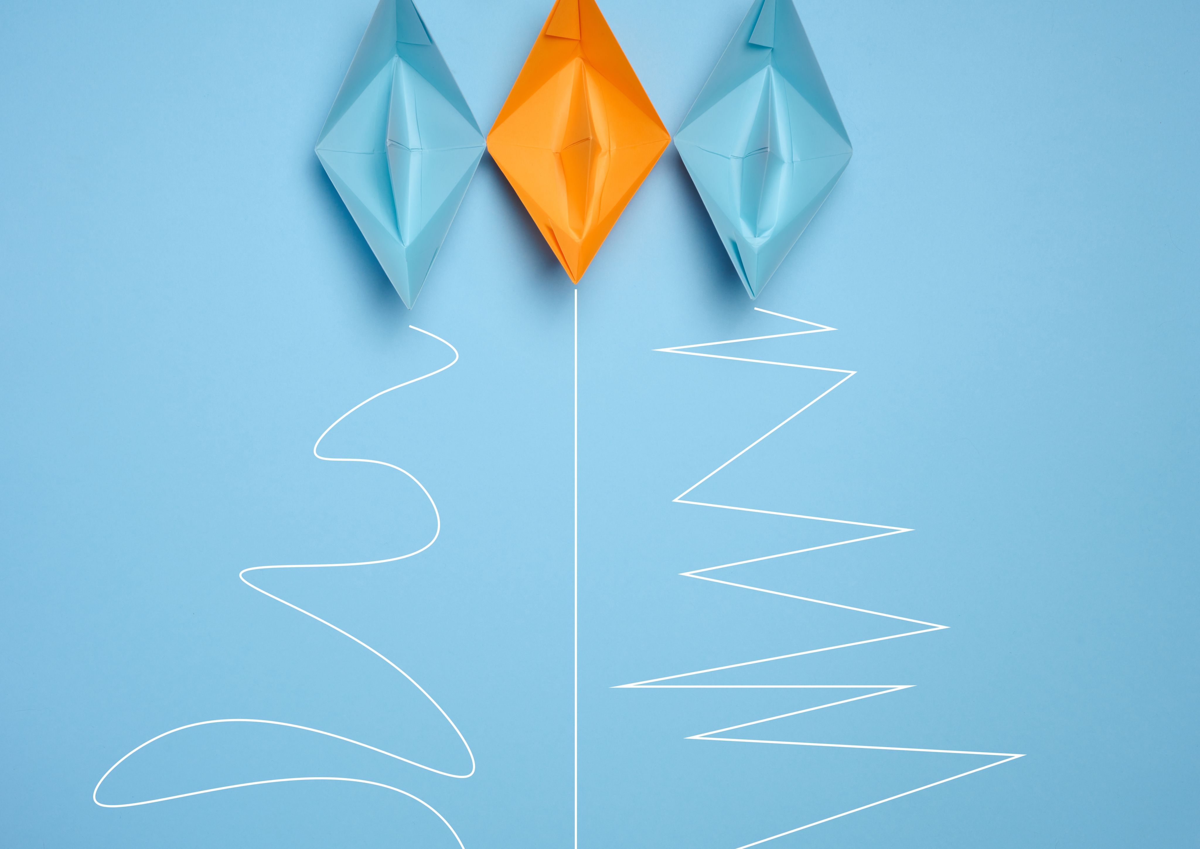 Folded paper boats against a light blue background