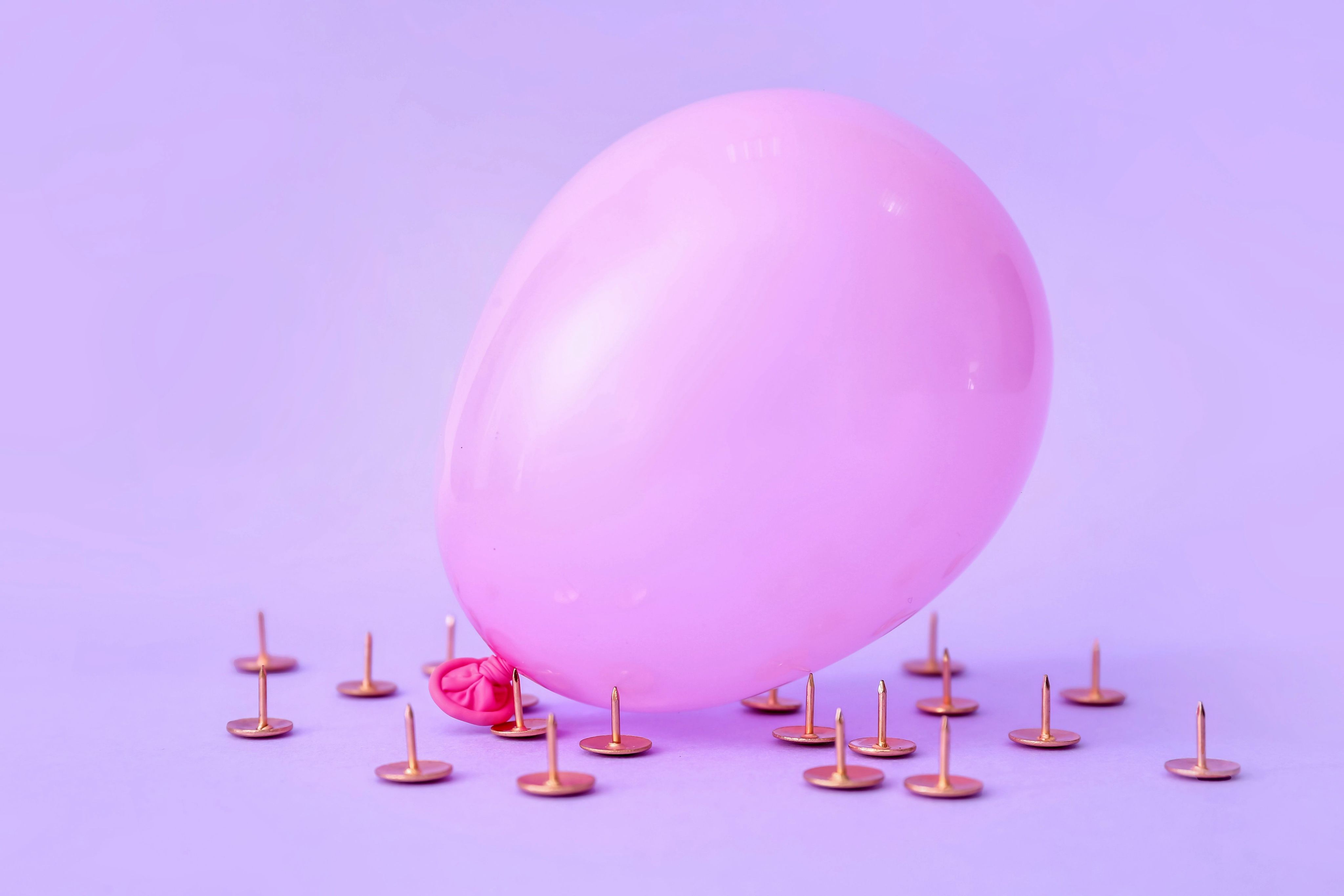 Pink balloon surrounded by pins