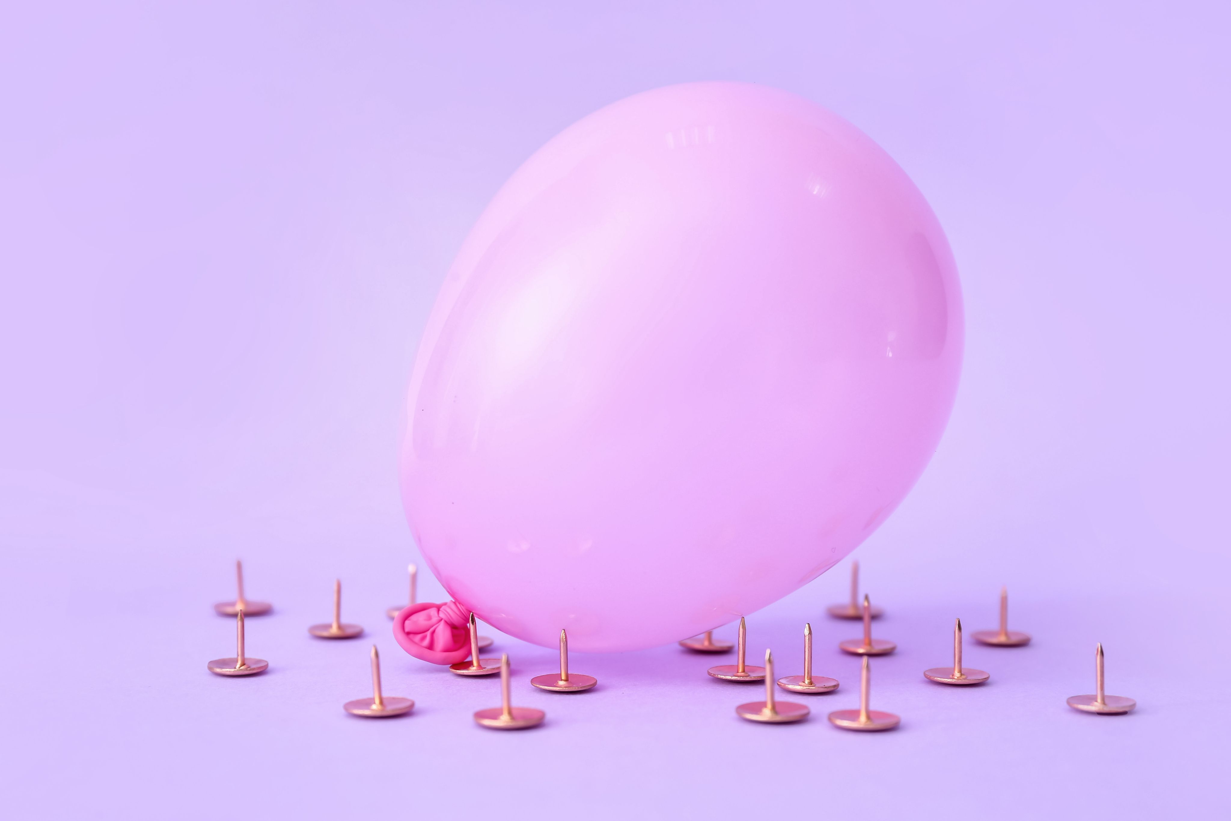 Pink balloon surrounded by pins